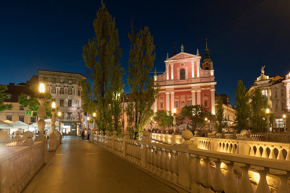 Franziskanerkirche Mariä Verkündigung und Dreifachbrücke bei Nacht, Ljubljana, Slowenien.