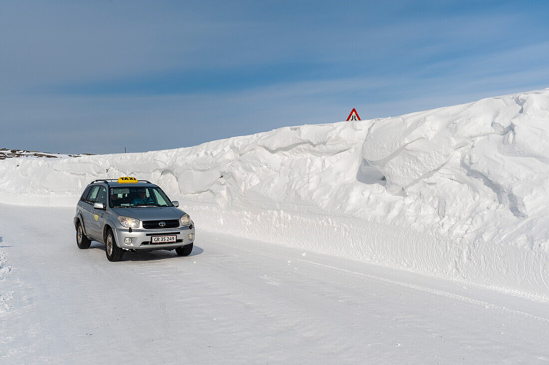 A taxi driving on a snow-covered road. Ilulissat, Greenland.