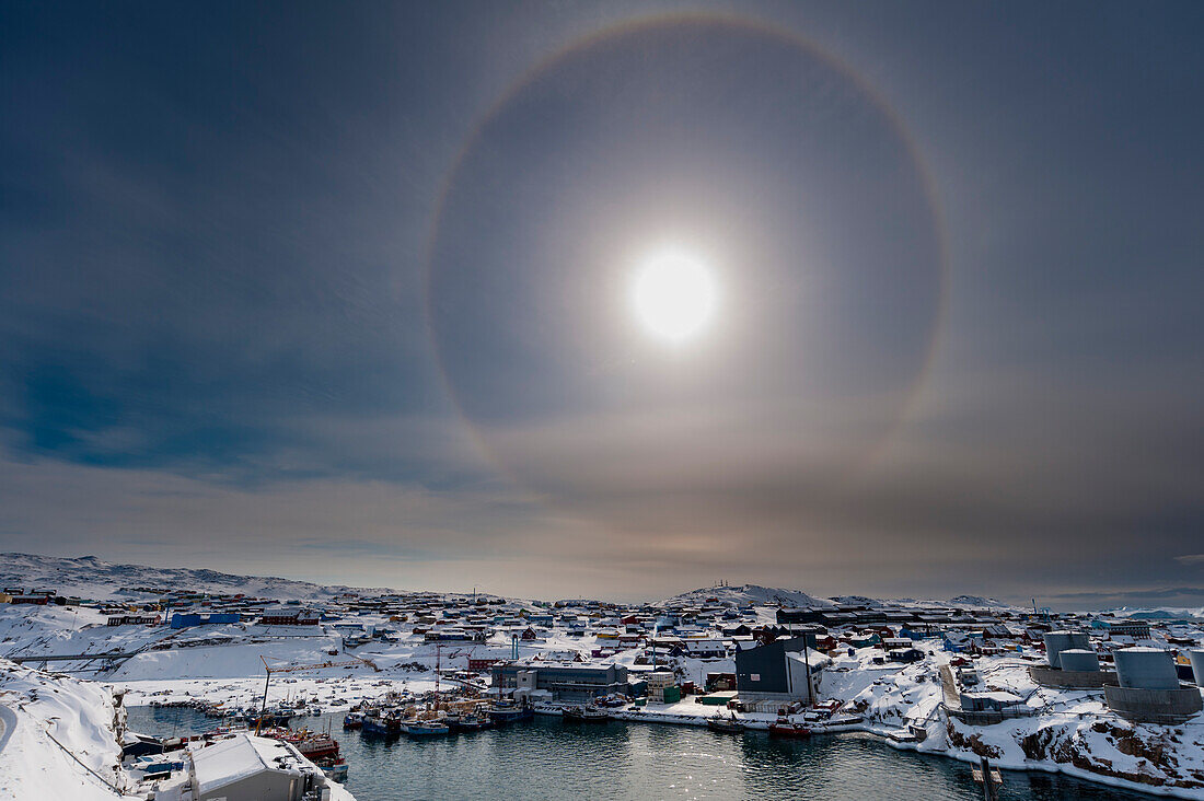 Ein Sonnenhalo, ein Phänomen, das durch die Wechselwirkung von Licht und Eiskristallen in der Atmosphäre entsteht. Ilulissat, Grönland.
