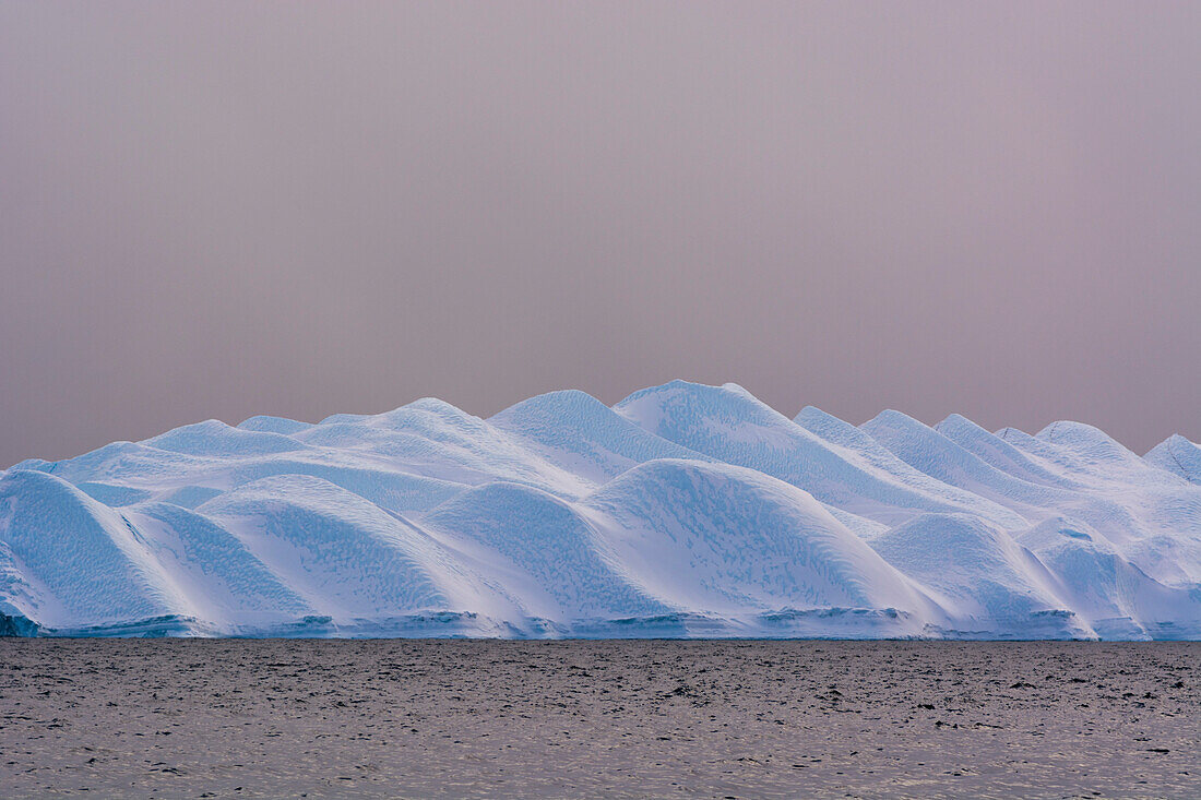 Ein Eisberg im Ilulissat-Eisfjord, einem UNESCO-Weltnaturerbe, an einem bewölkten Tag. Ilulissat-Eisfjord, Ilulissat, Grönland.