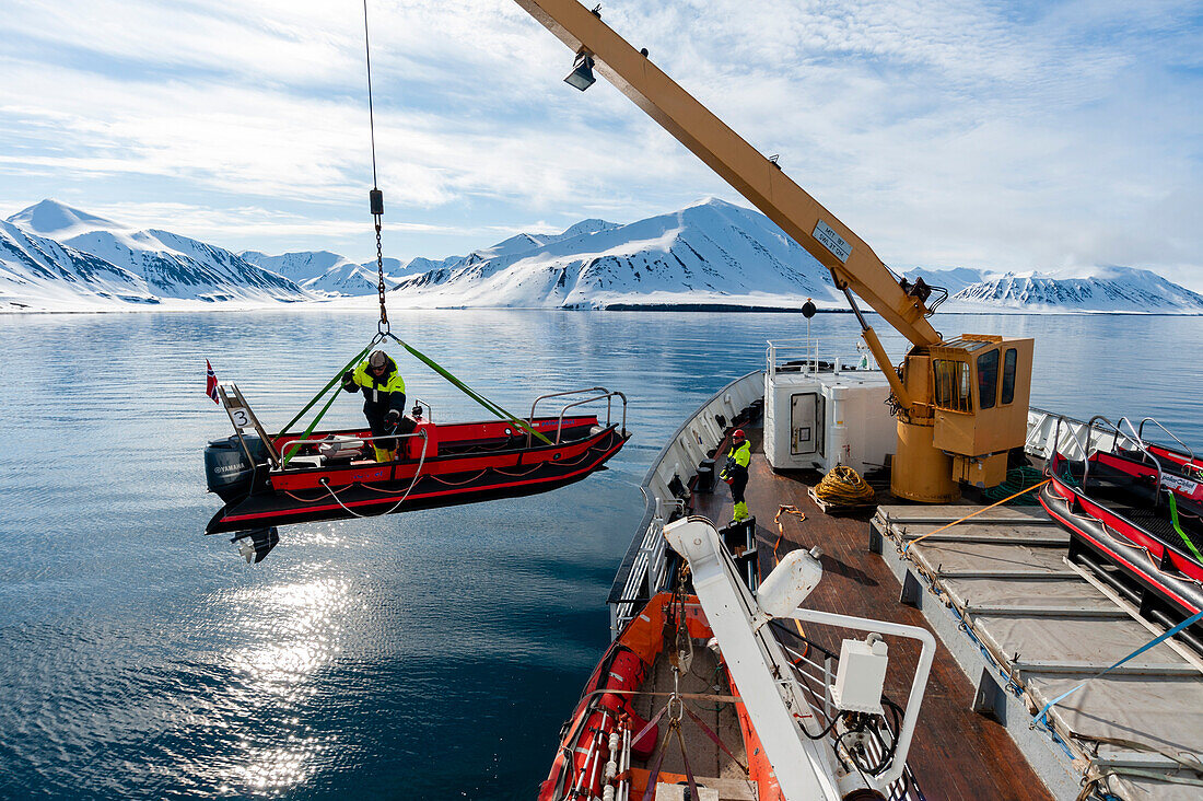 A motorized raft is launched from a cruise ship on Mushamna Bay. Spitsbergen Island, Svalbard, Norway.