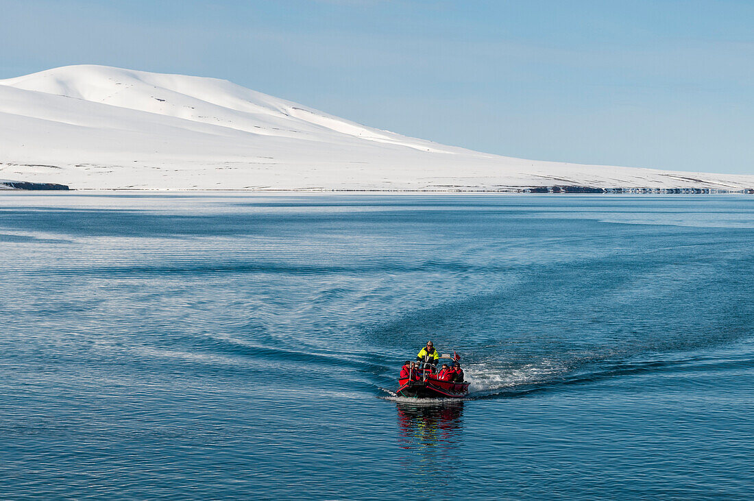 Ecotourists travel across Bockfjorden in an inflatable raft. Bockfjorden, Spitsbergen Island, Svalbard, Norway.
