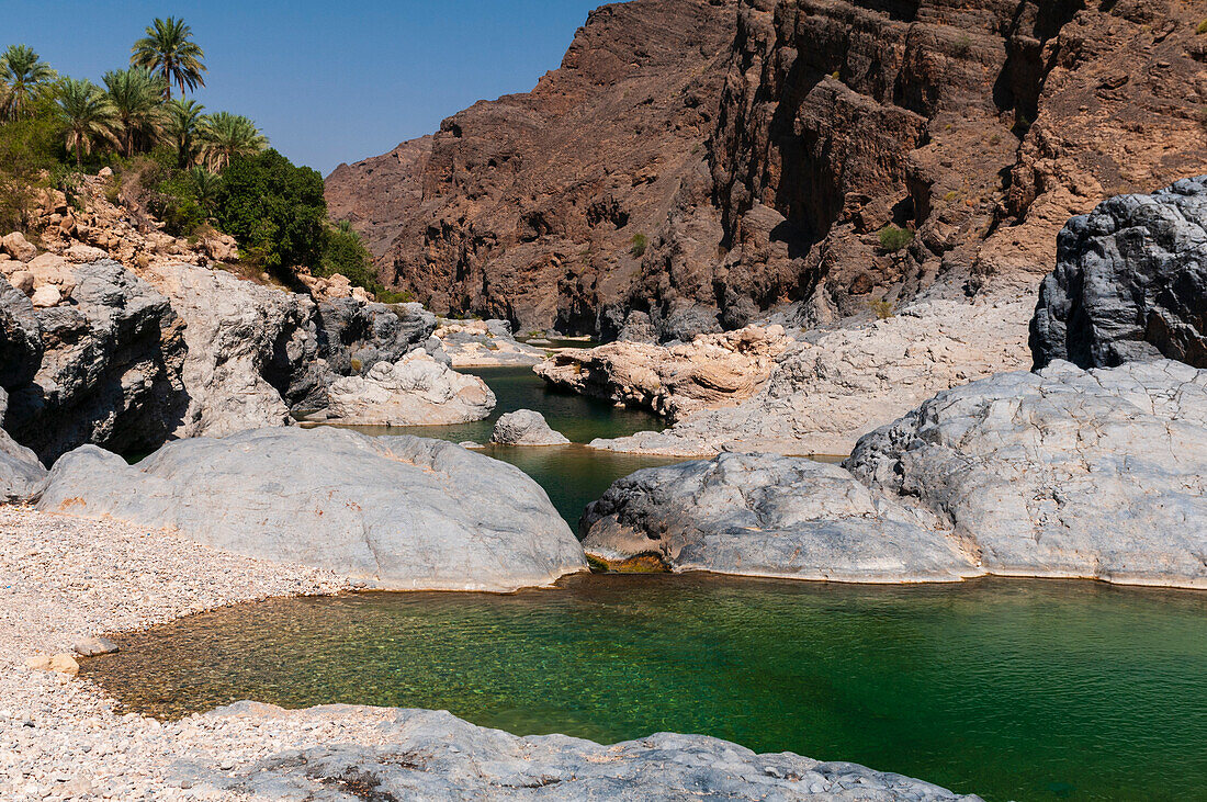 A natural pool at Wadi Al Arbeieen, at the foot of desert mountains. Wadi Al Arbeieen, Oman.