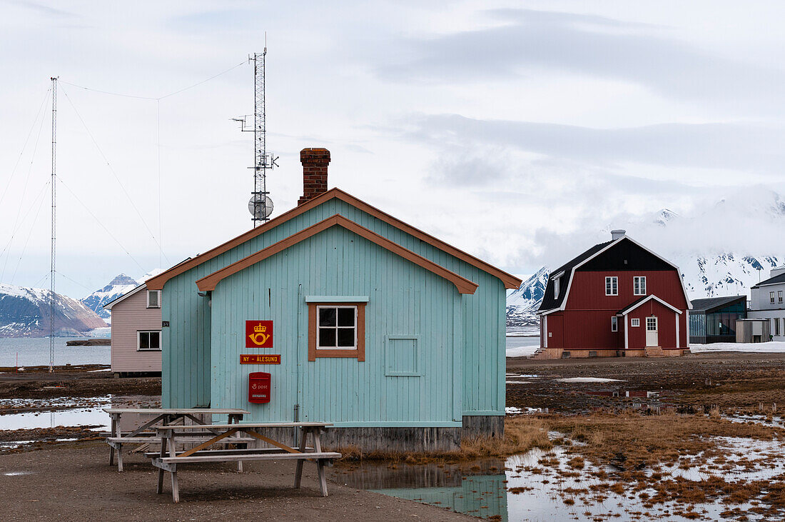 Das Postamt von Ny-Alesund und ein rotes Haus im Hintergrund, in dem Roald Amundsen wohnte. Ny-Alesund, Kongsfjorden, Insel Spitzbergen, Svalbard, Norwegen.