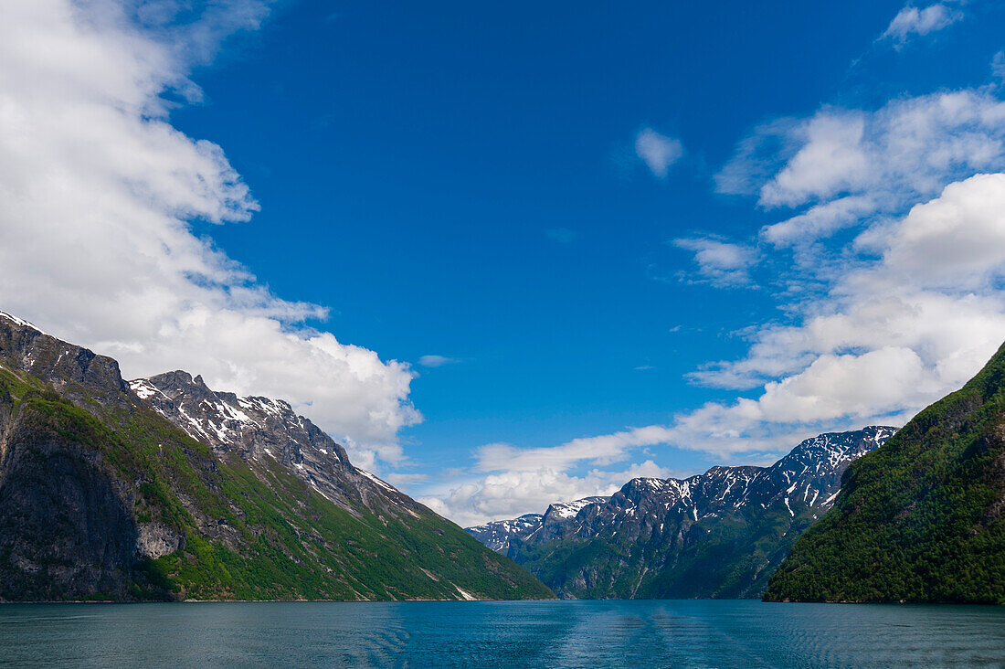 Steile, zerklüftete Berge erheben sich aus den Gletschergewässern des Geirangerfjordes. Geirangerfjord, Norwegen.