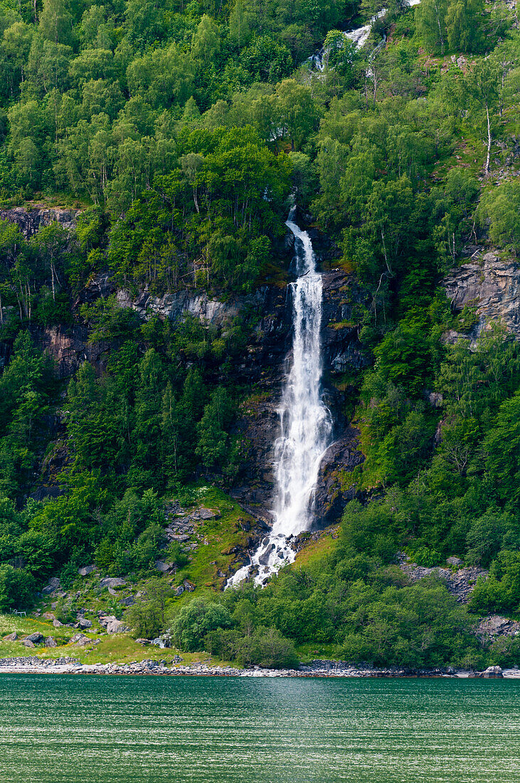 Ein Wasserfall stürzt von steilen Klippen in den Geirangerfjord. Geiranger, Geirangerfjord, Norwegen.