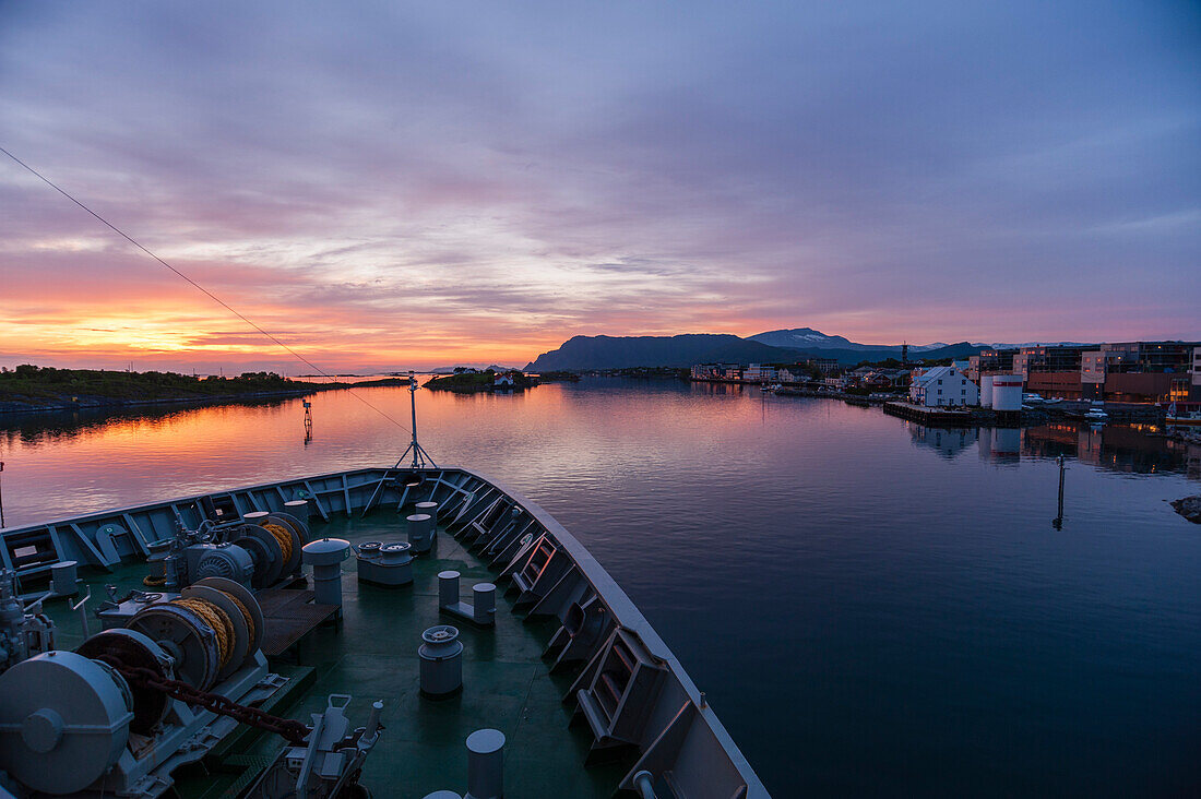 Ein Kreuzfahrtschiff läuft bei Sonnenuntergang in den Hafen der Küstenstadt Broennoysund ein. Broennoysund, Bronnoy, Nordland, Norwegen.