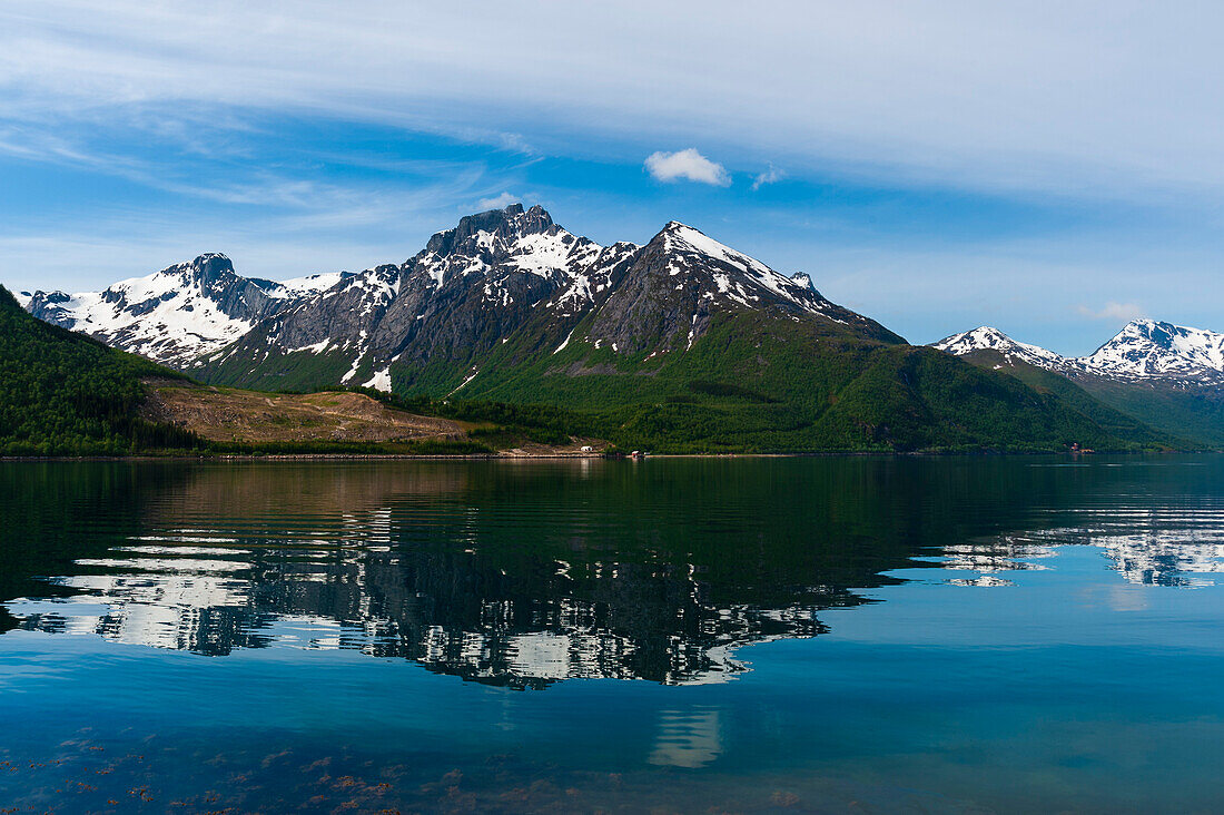 Eisbedeckte Berge spiegeln sich im Holandsfjord in der Nähe des Svartisen-Gletschers. Saltfjellet Svartisen-Nationalpark, Svartisen, Norwegen.