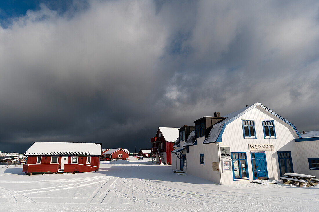 Snow-covered houses and roads under a cloudy sky. Andenes, Vesteralen Islands, Nordland, Norway.
