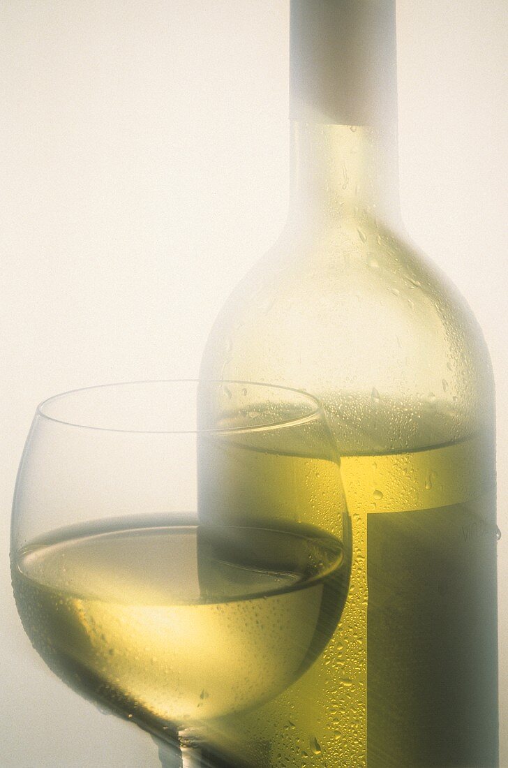 Well-chilled white wine in wine glass and bottle