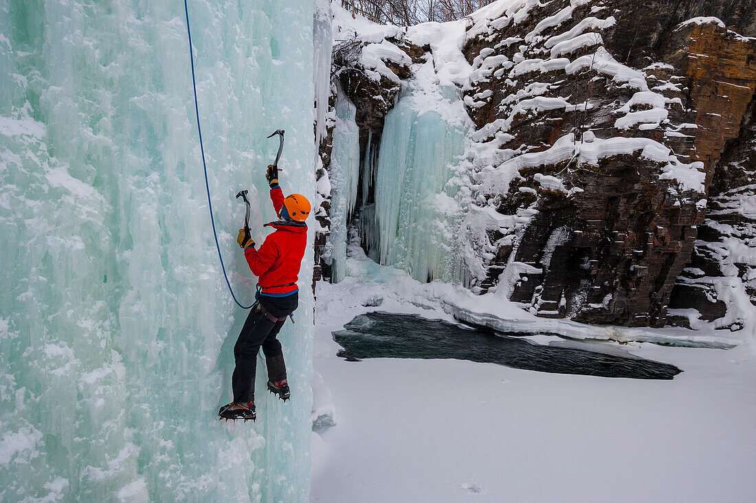 Eisklettern an einem gefrorenen Wasserfall im Abisko-Nationalpark, Schweden. MR