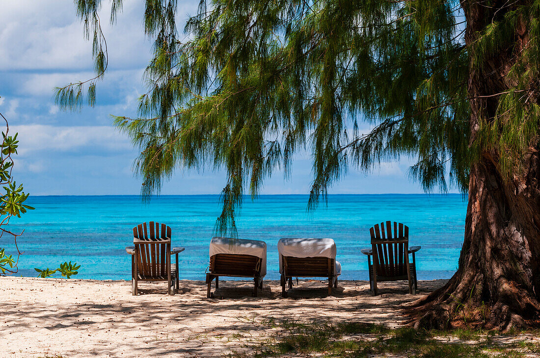 Liegestühle an einem tropischen Sandstrand am Indischen Ozean. Die Insel Denis, Republik Seychellen.