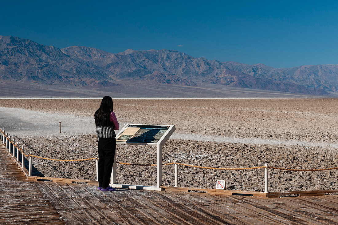 A tourist on the observation deck of Badwater Basin. Death Valley National Park, California, USA.