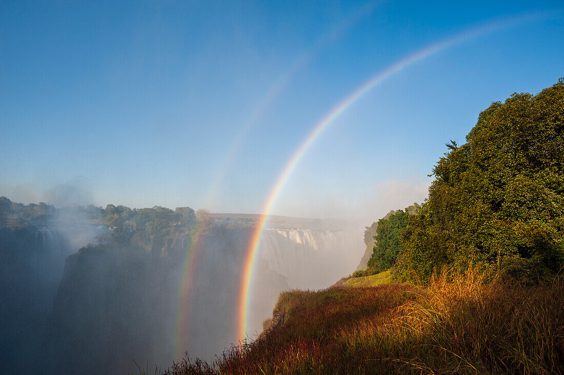 Ein doppelter Regenbogen über den Victoriafällen. Victoria Falls National Park, Simbabwe.