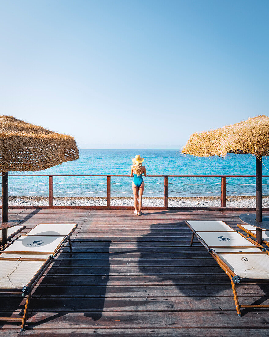 Ein Mädchen genießt den Blick aufs Meer bei Villasimius, Provinz Cagliari, Sardinien, Italien