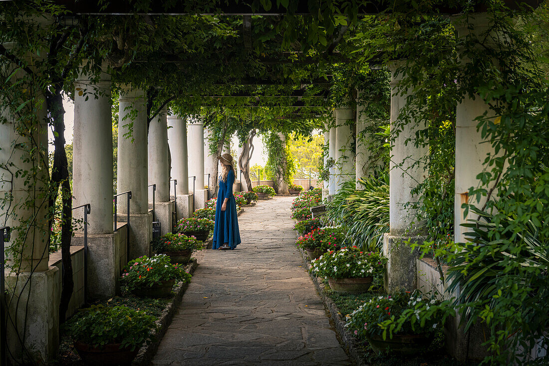 Ein Mädchen spaziert im Garten der Villa Lysis, Insel Capri, Kampanien, Italien