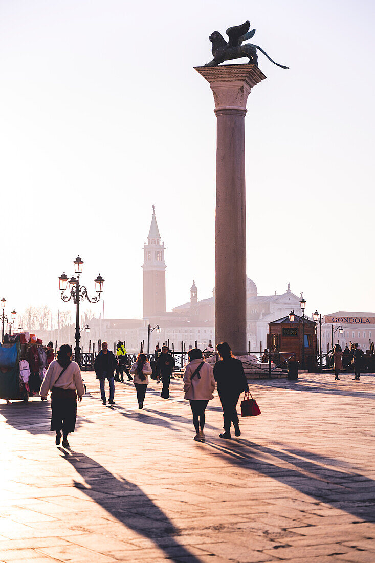 Menschen überqueren den Markusplatz, Venedig, Venetien, Italien