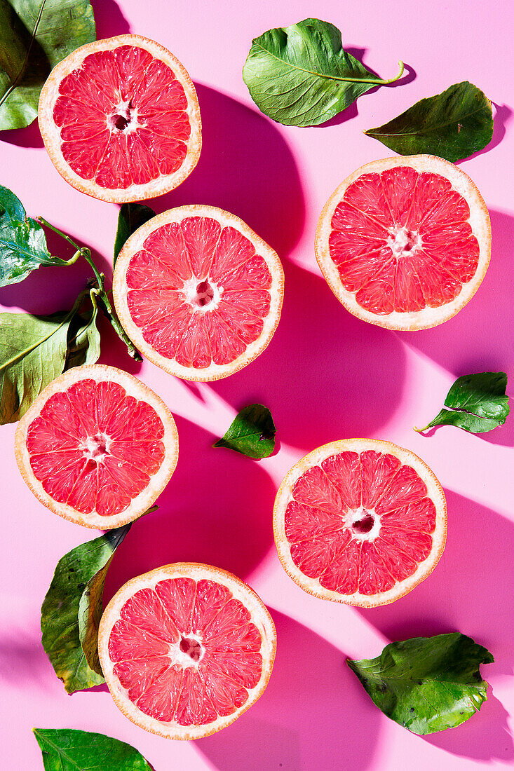Halved pink grapefruits with leaves