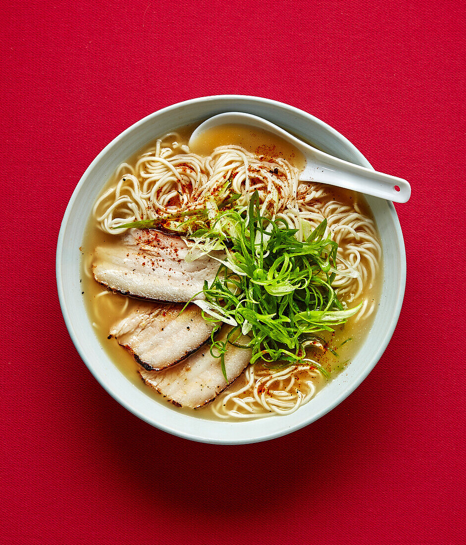 Hakata-style ramen soup with spring onions and pork belly