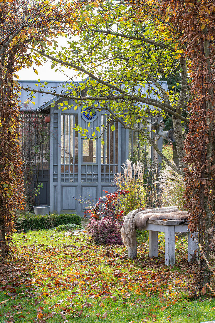 Autumn garden with garden house and bench