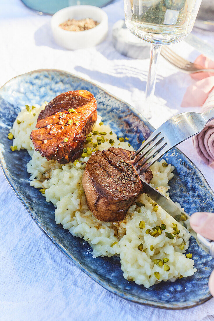 Pork tenderloin on risotto with pistachios