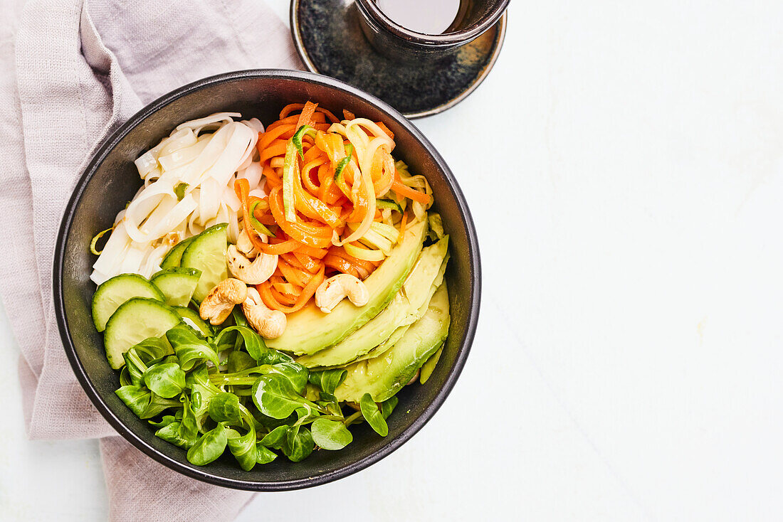 Asia Bowl mit Reisbandnudeln, Feldsalat, Gurke, Avocado und Karotten