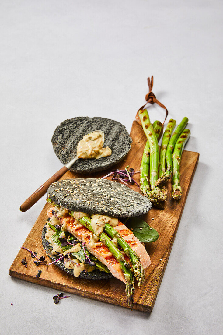 Salmon and asparagus on black bun
