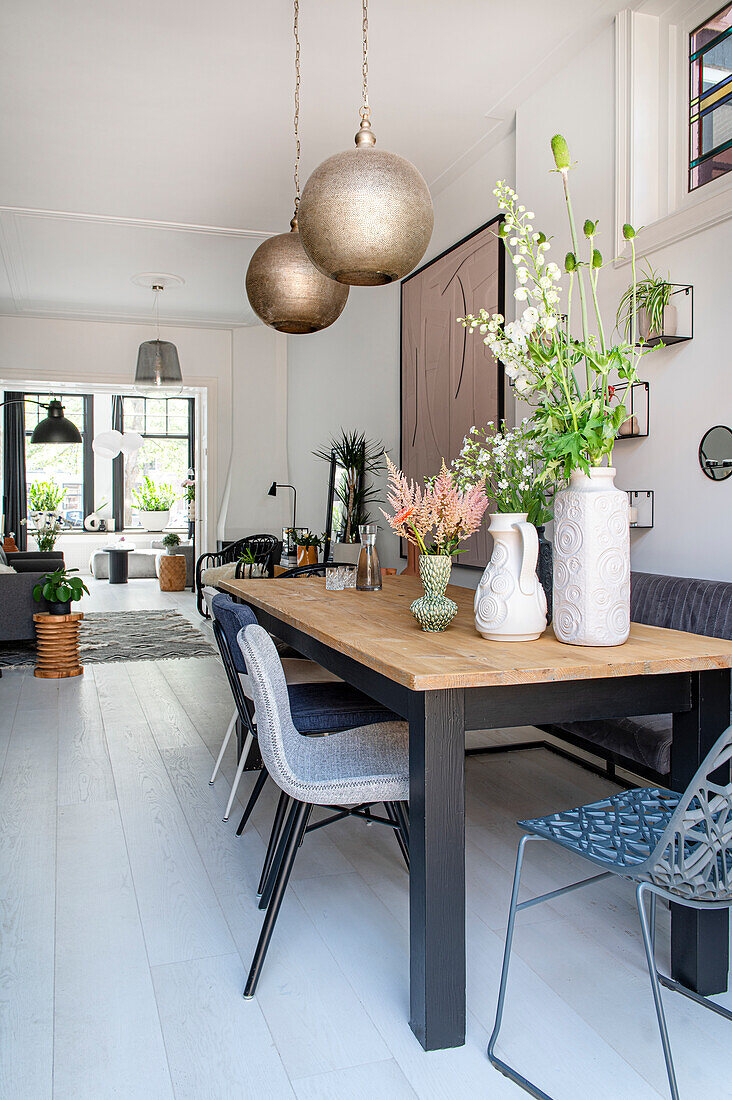 Dining area with various chairs, ball lights above table