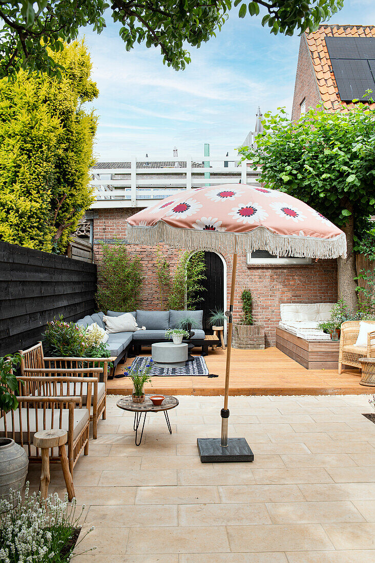 Große Terrasse mit verschiedenen Sitzmöbeln und Bodenbelägen