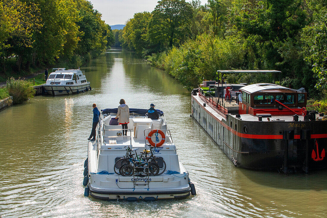 Der Canal du Midi, in der Nähe von Carcassonne, französisches Departement Aude, Region Occitanie, Languedoc-Rousillon Frankreich. Boote, die auf dem von Bäumen gesäumten Kanal vertäut sind. Die Herminis-Schleuse oder Herminis ecluse.