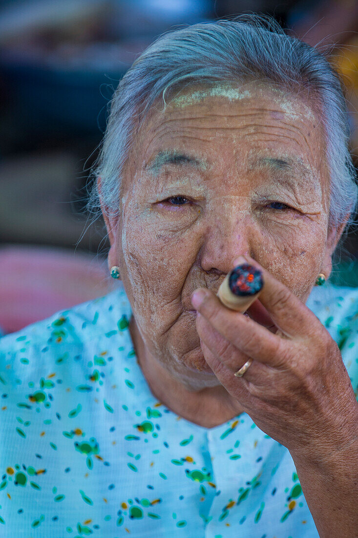 Woman smoking a cheroot cigar in market in Bagan, Myanmar