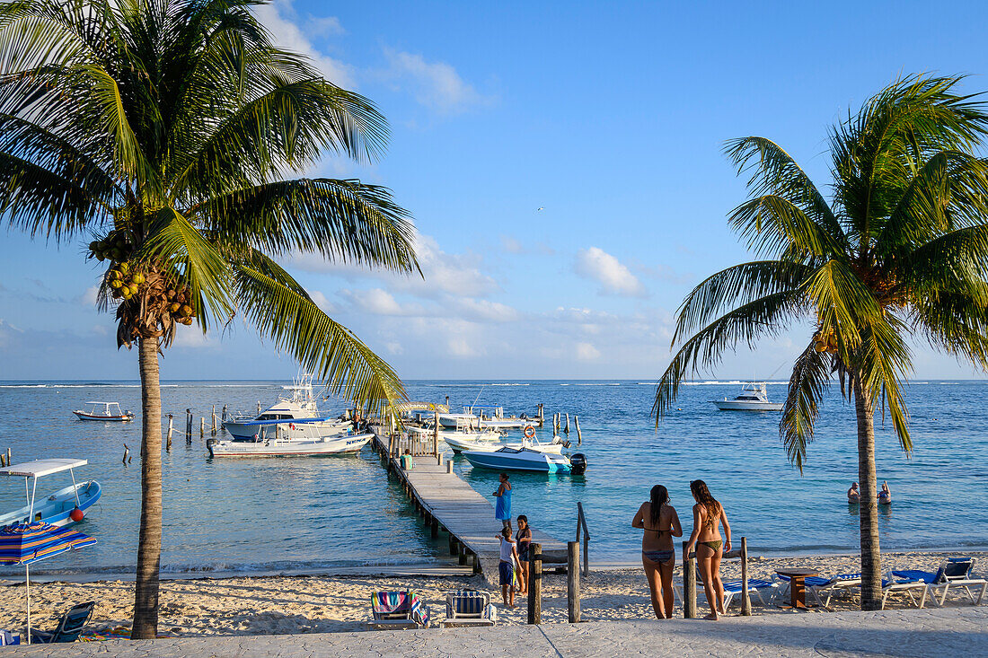 Beach and Pelicanos Yacht Club pier from the malecon in Puerto Morelos, Riviera Maya, Mexico.
