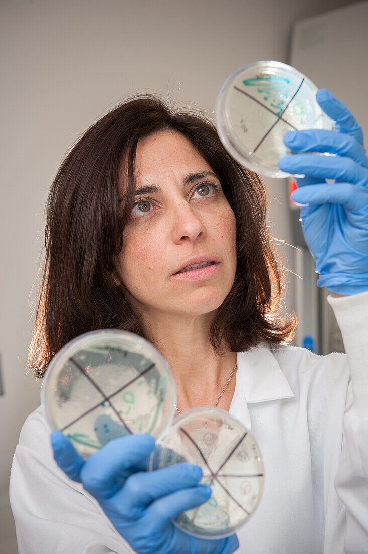 Woman in white lab coat holding up specimens in College Park, Maryland