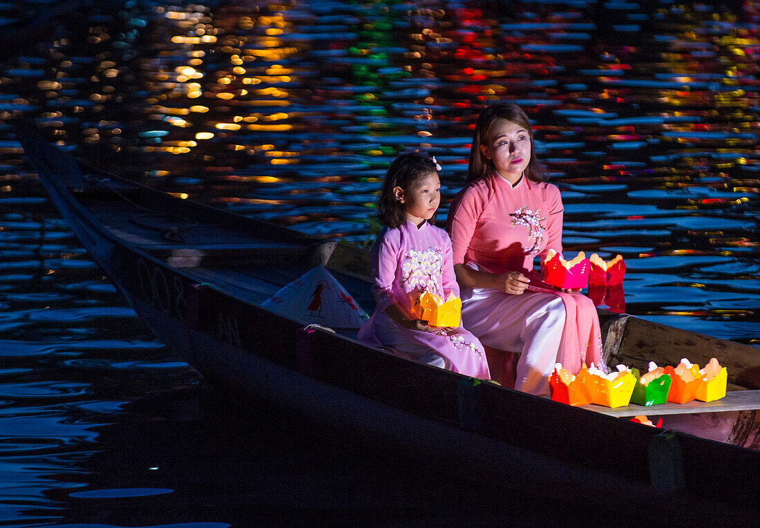 Vietnamese mother and daughter holding Lanterns before droping them into the River in Hoi An Vietnam