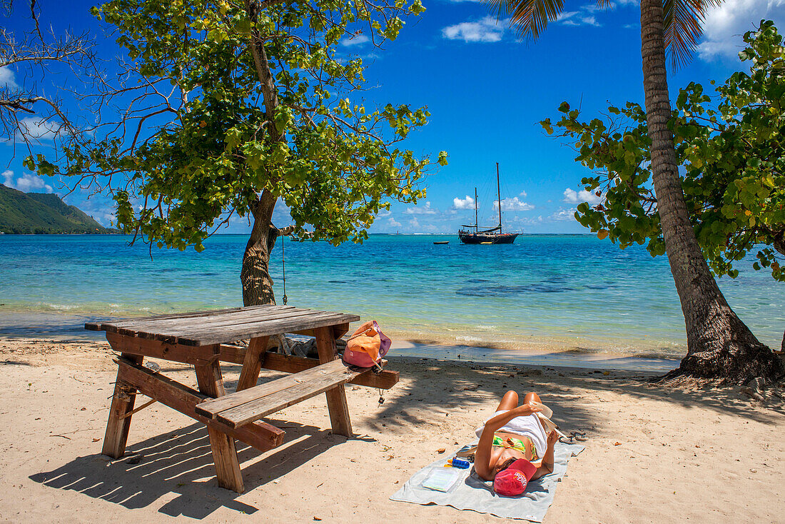 Tourist girl in public beach Opunohu Beach and Ta'ahiamanu beach in Moorea, Cook's Capitan Bay, French Polynesia, Society Islands, South Pacific.