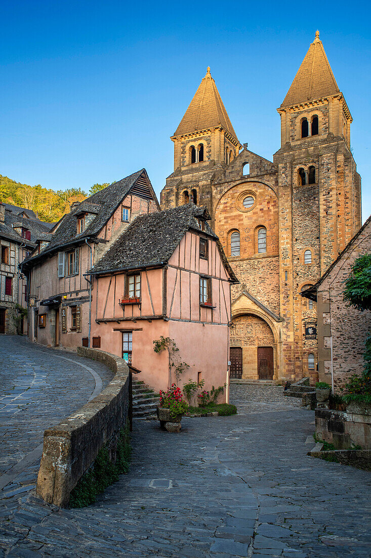Das kleine mittelalterliche Dorf Conques in Frankreich. Es zeigt dem Besucher seine Abteikirche und die mit Schieferdächern gedeckten Häusergruppen. Kreuzung von engen Gassen und Monolithen für die Gefallenen des Krieges im alten mittelalterlichen Dorf Conques am Ufer des Flusses Dordou