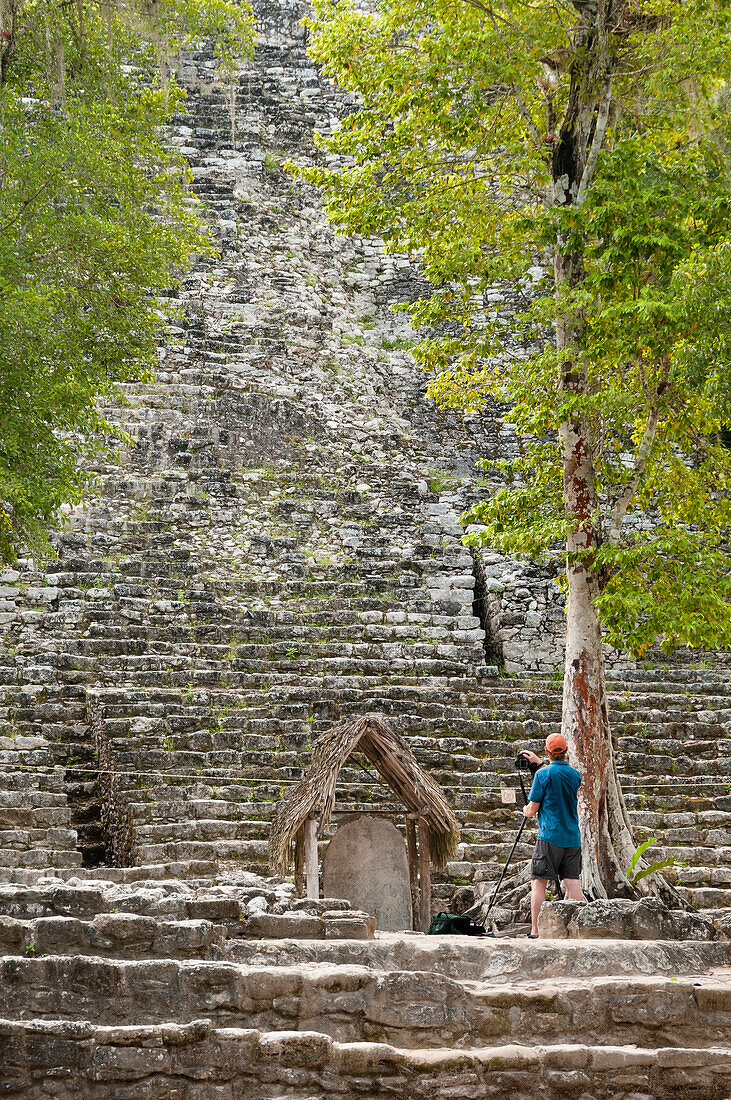 Fotograf in La Iglesia (Kirchenpyramide) in den Mayaruinen von Coba, Quintana Roo, Mexiko.