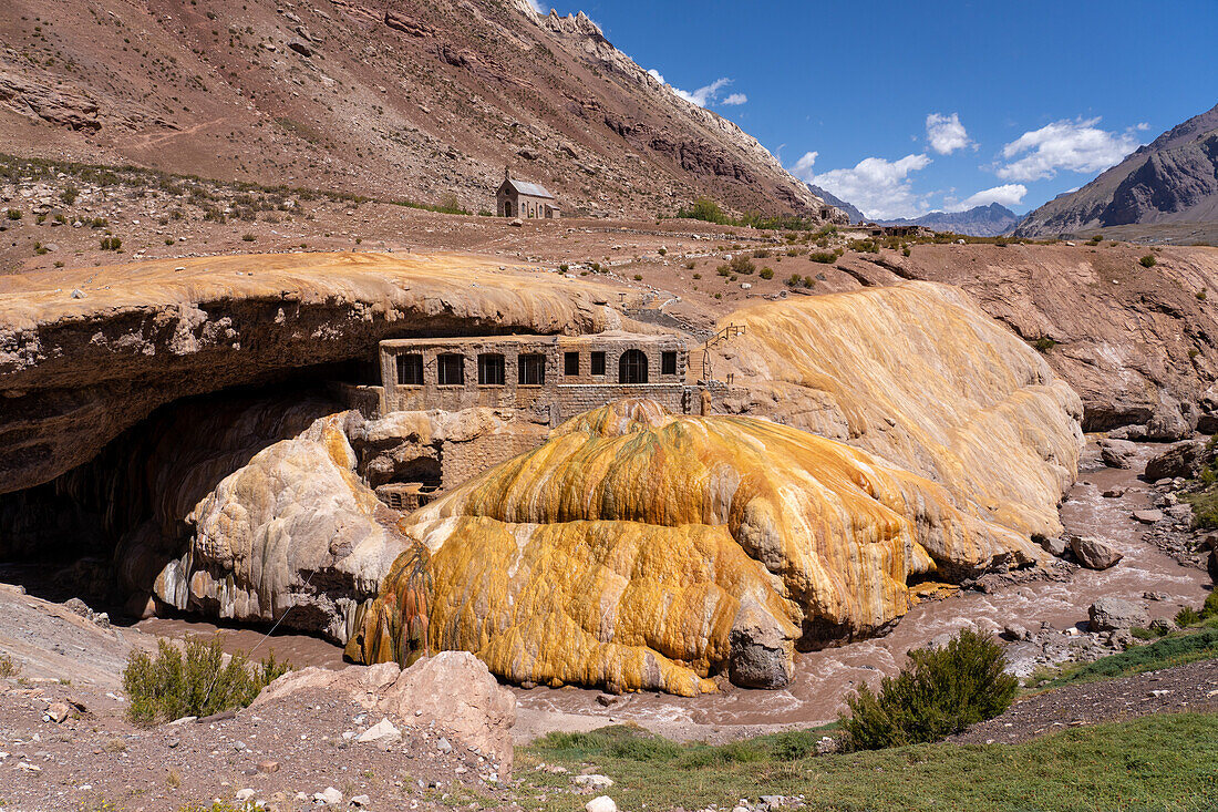 Colorful travertine deposits of the mineral spring at Puente del Inca in the Andes Mountains of Argentina, with the ruins of a former spa.