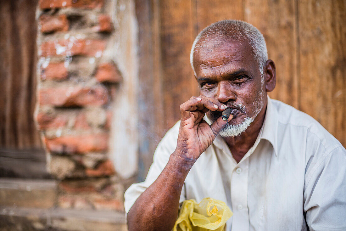 Portrait of a man smoking a cigar on the streets of Negombo on the West Coast of Sri Lanka, Asia