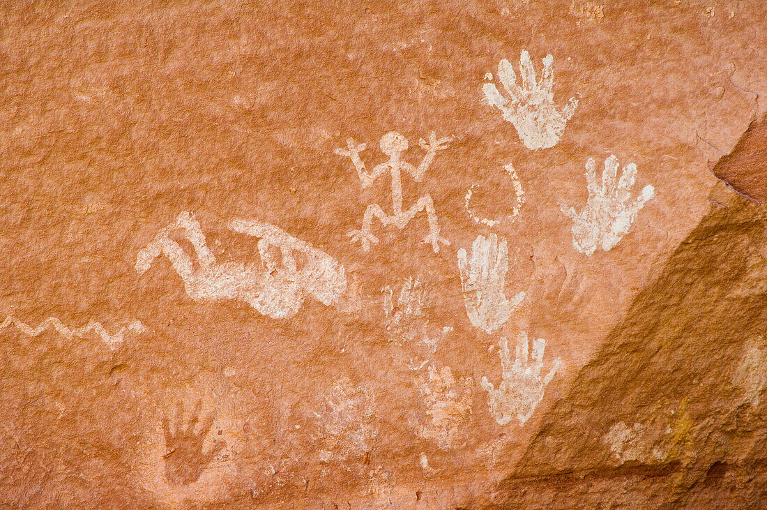 Native American pictographs, including Kokopeli and hand shapes, on sandstone walls of Chinle Wash; Canyon de Chelly National Monument, Arizona.