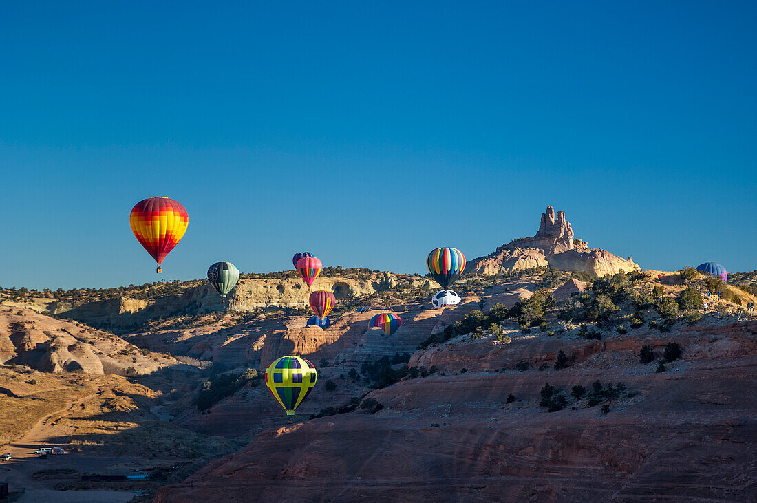 Heißluftballons mit Church Rock im Hintergrund; Red Rock Balloon Rally im Red Rock State Park, Gallup, New Mexico.