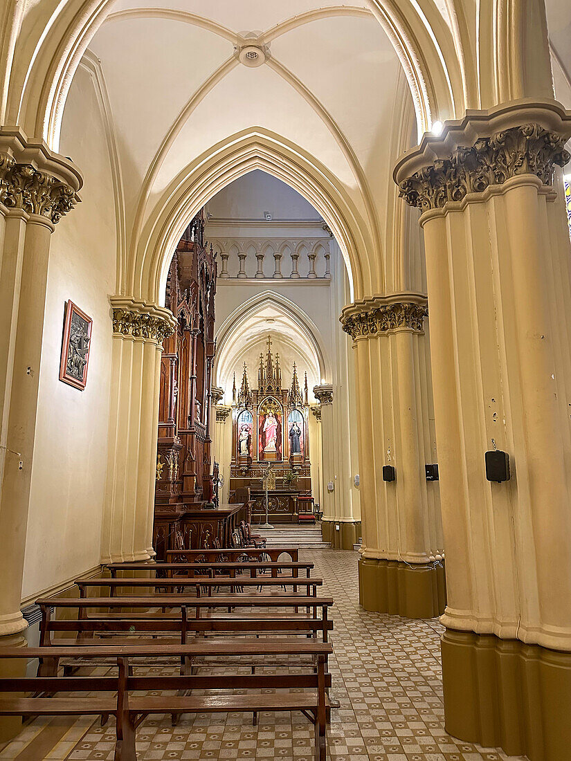 An aisle and carved wooden altarpiece in the San Vicente Ferrer Church in Godoy Cruz, Mendoza, Argentina.