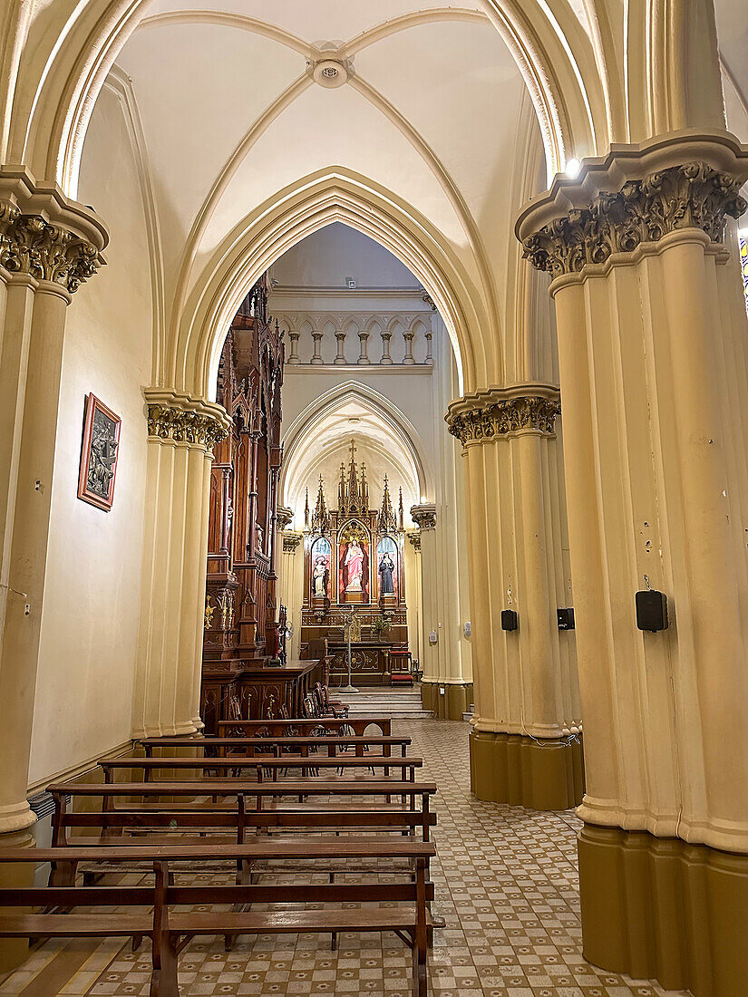 Ein Kirchenschiff und ein geschnitztes Holzaltarbild in der Kirche San Vicente Ferrer in Godoy Cruz, Mendoza, Argentinien.