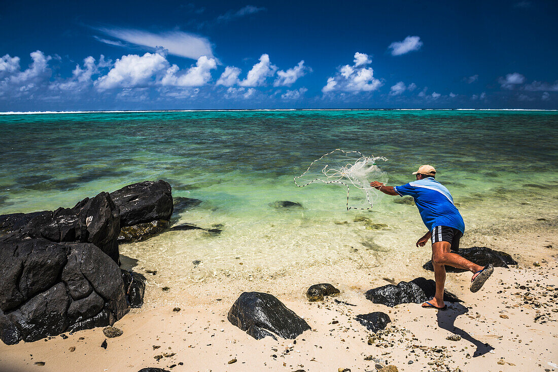 Fisherman net fishing from a beach in Muri, Rarotonga, Cook Islands