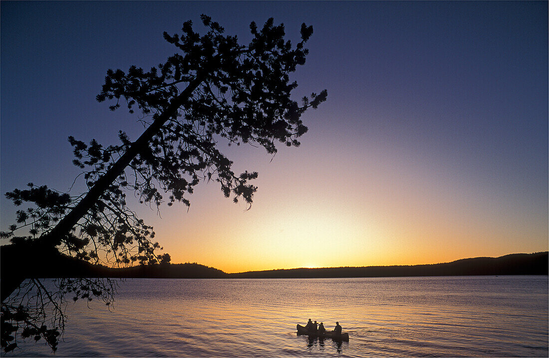 Paulina Lake at sunset, with family in canoe; Newberry Crater National Volcanic Monument, Oregon.
