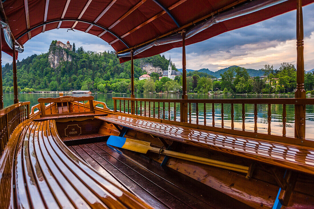 Pletna rowing boat and Lake Bled Castle, Slovenia in Bled, Julian Alps, Gorenjska, Upper Carniola Region, Slovenia, Europe