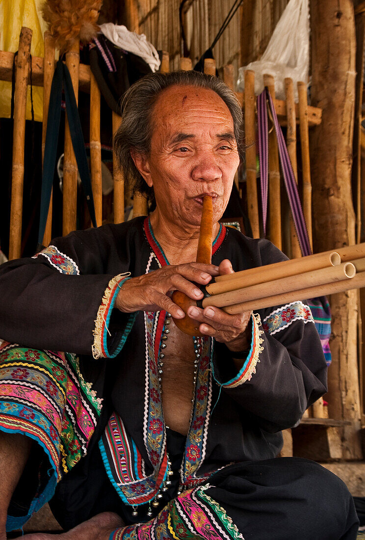 Mann spielt eine Art Flöte in Baan Tong Luang, einem Dorf der Hmong in der ländlichen Provinz Chiang Mai, Thailand.