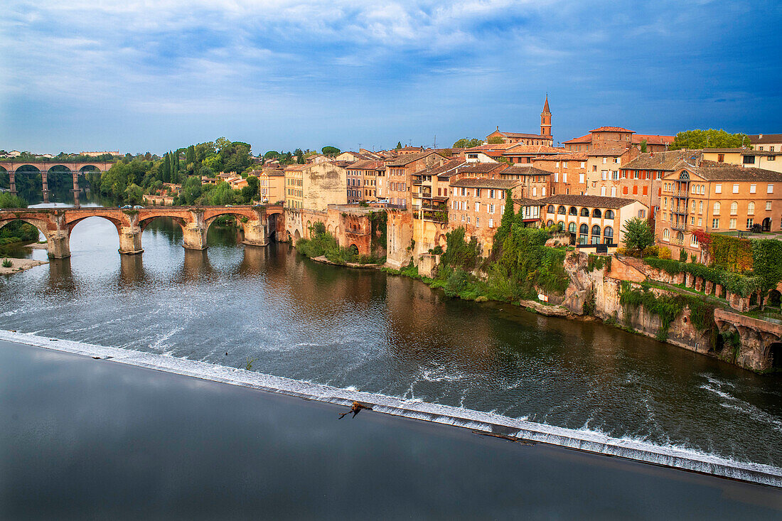 Der Fluss Tarn durchquert die Stadt Albi. Brücke Pont Vieux und die Kirche Notre Dame du Breuil im Dorf Tarn, Occitanie Midi Pyrenees, Frankreich.