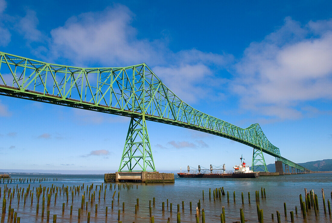 Freighter ship passing under the Astoria-Megler Bridge, connecting Oregon and Washington at the mouth of the Columbia River.