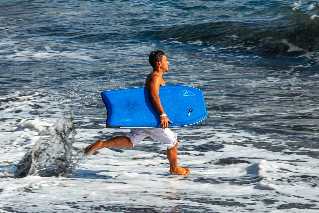 Surfers at Beach with black sand on Pointe Venus, Tahiti, French Polynesia, Tahiti Nui, Society Islands, French Polynesia, South Pacific.